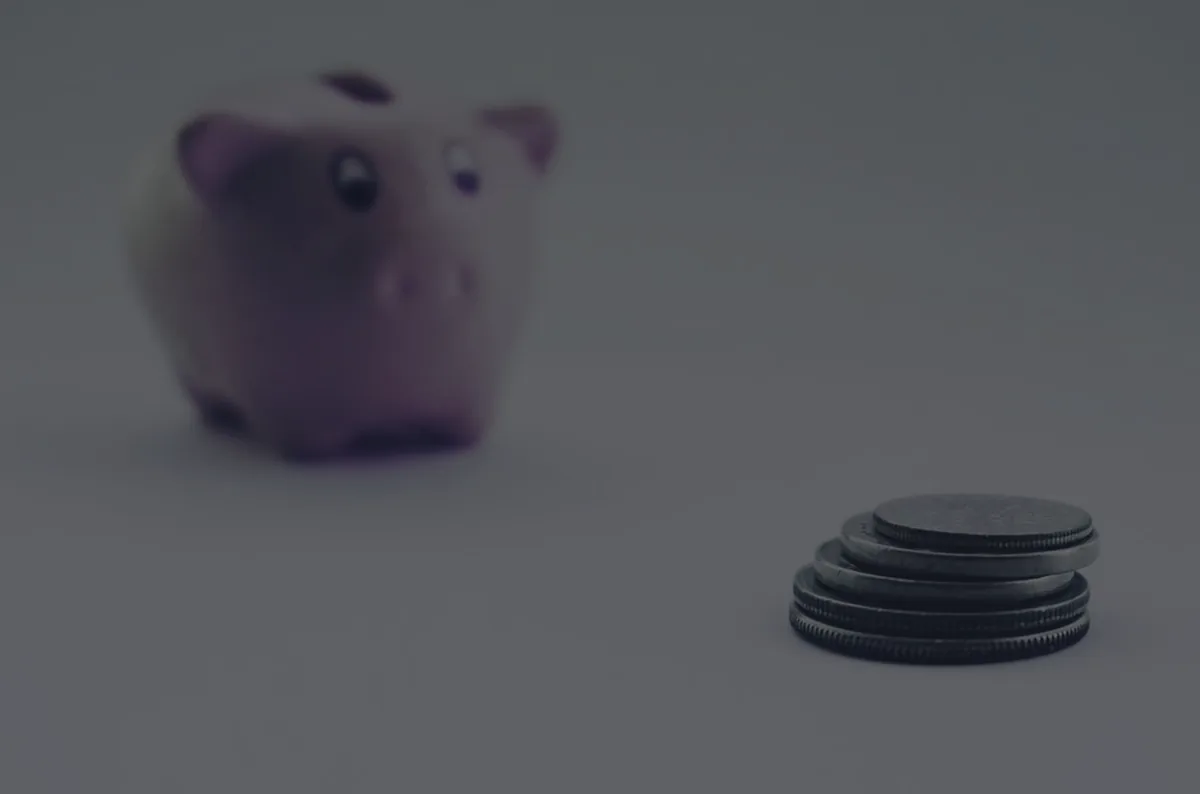 A piggy bank beside stacked coins, representing 529 college savings plans.