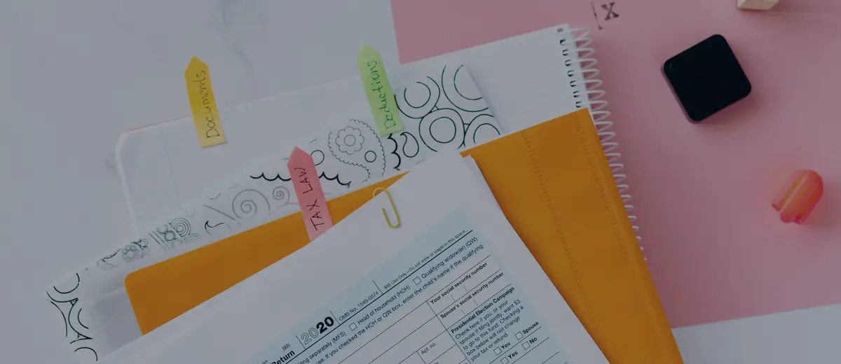 A tax form with colored sticky notes on a desk.