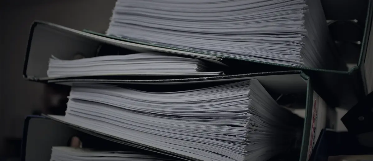 Stacked binders full of paper records.