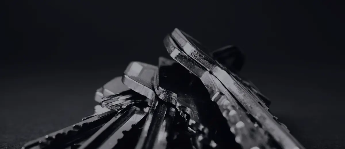 A bunch of metal keys against a dark background.