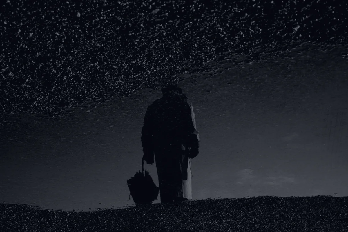 A silhouetted figure with an umbrella in rain, representing disability insurance.