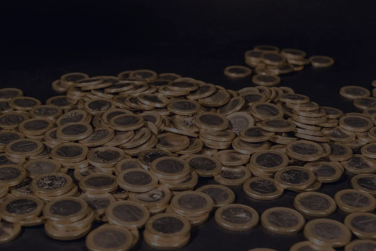 Stacks of gold coins on a dark surface, representing dividend income from a portfolio.