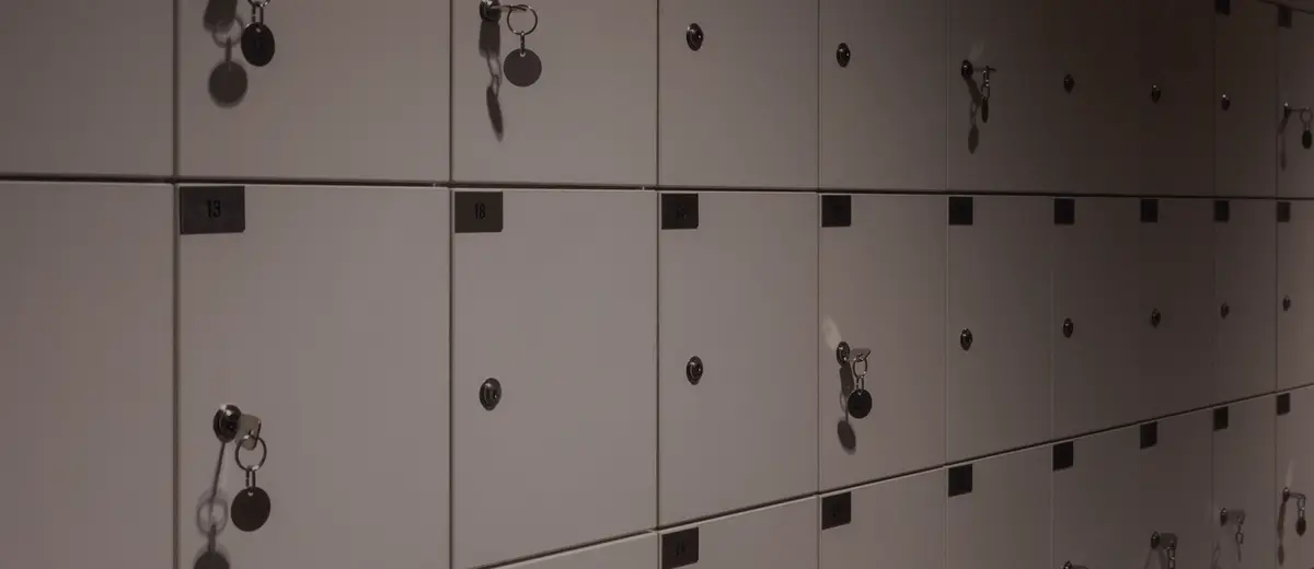 Rows of safe deposit boxes with keys in their locks.