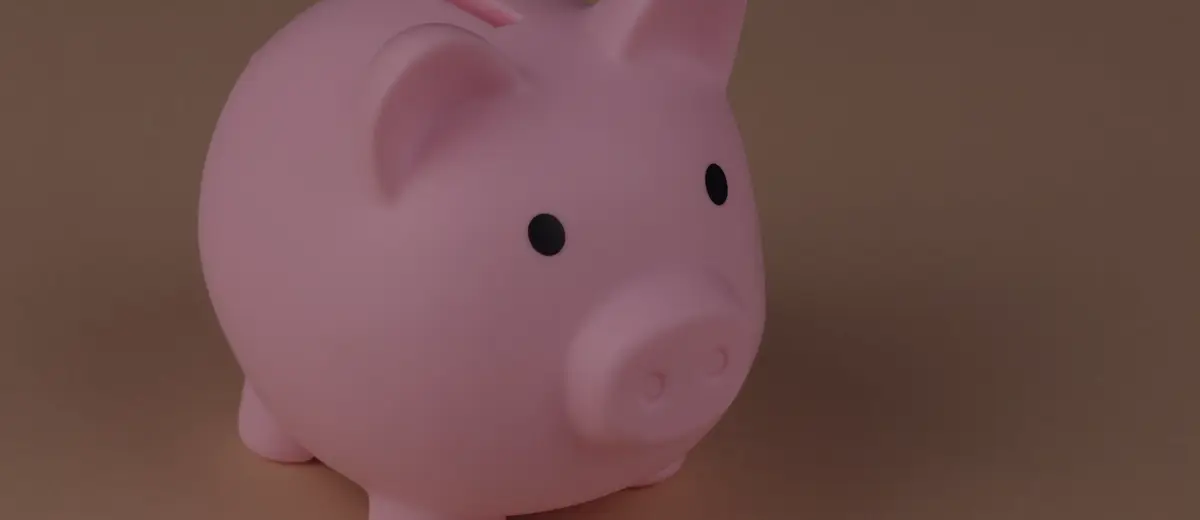 A pink piggy bank on a peach-colored background.