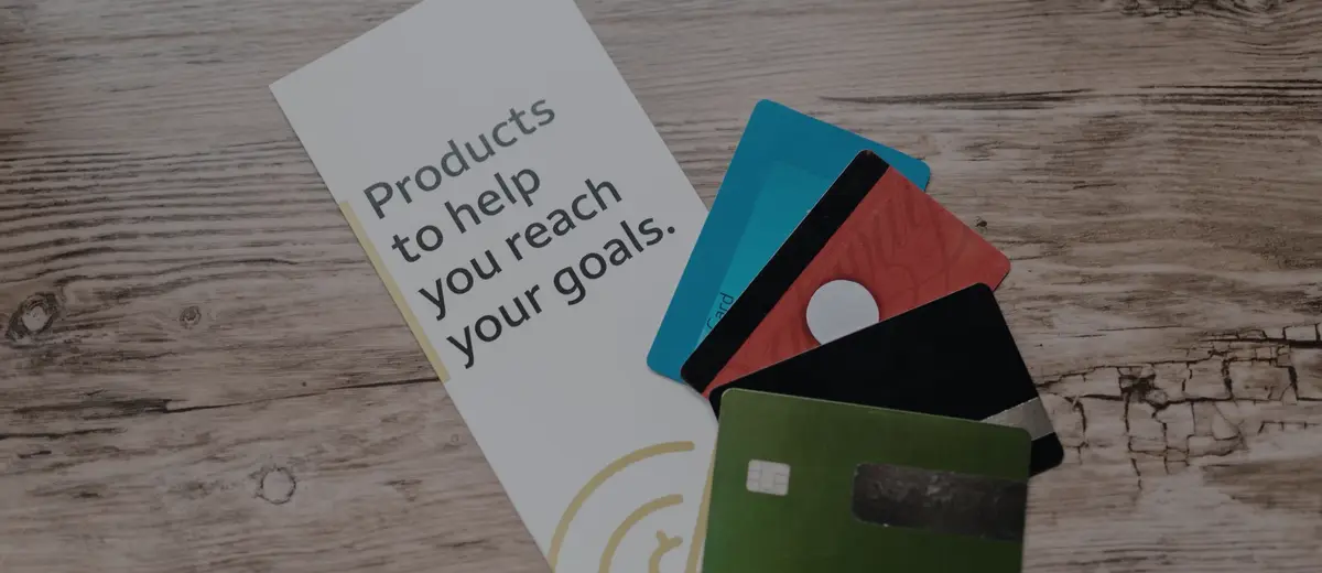 Three credit cards fanned out on a wooden table.