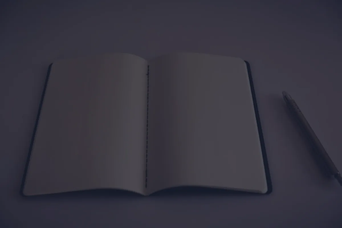 An open notebook on a dark desk, representing how to create a budget.