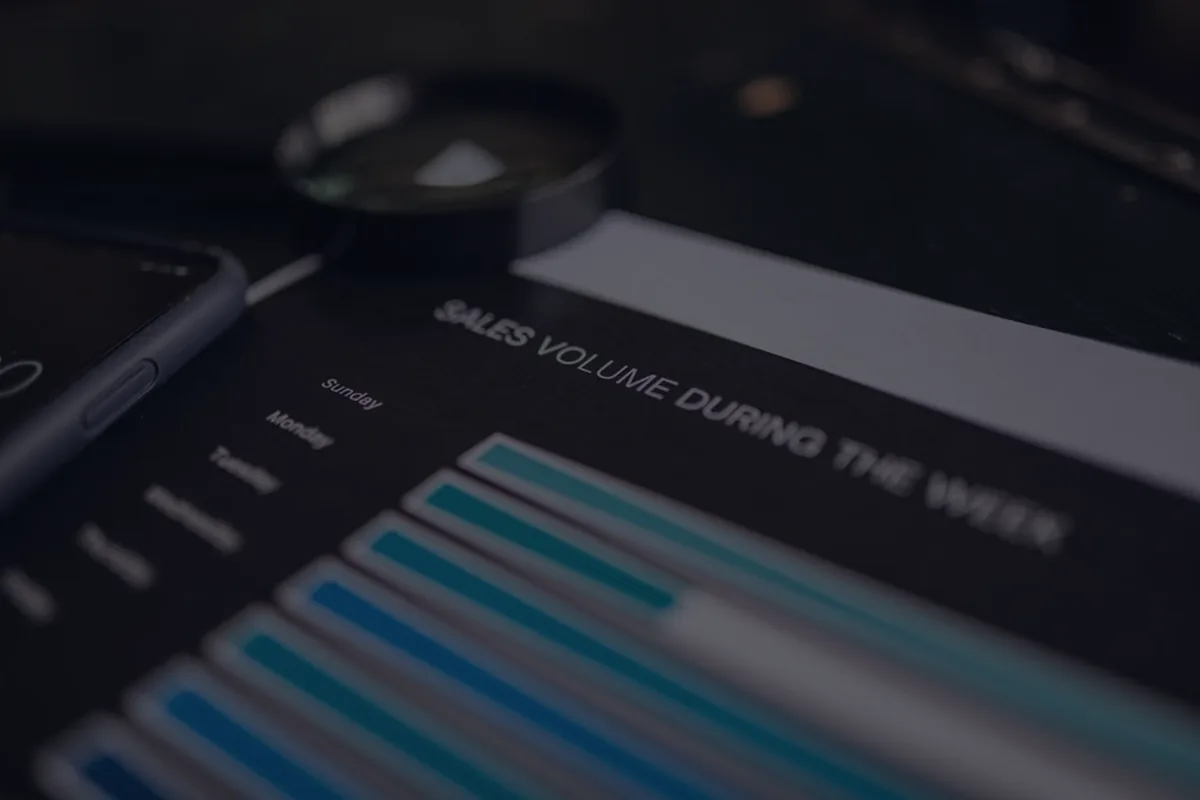 A magnifying glass over a document on dark, representing how to read a credit report.