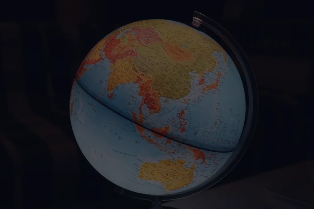 A warm-lit globe on a dark background, representing global diversification in an investment portfolio.