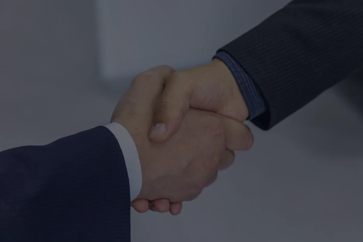 A handshake in dark tones, representing evaluating a job offer.