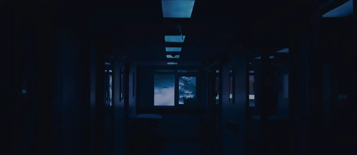 A dark hospital corridor lit in blue.