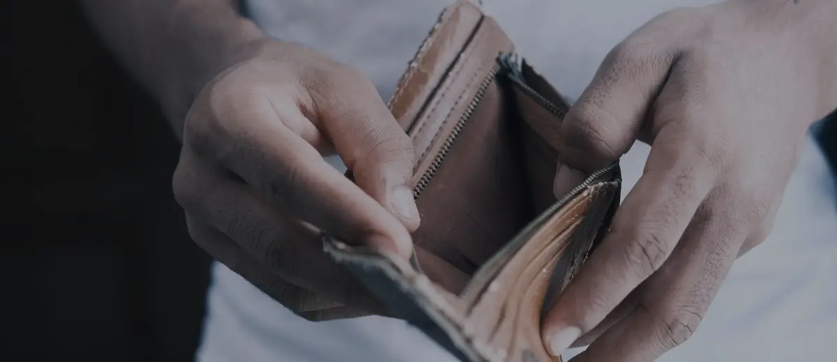 Hands opening an empty brown leather wallet.
