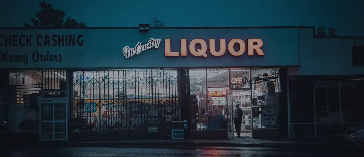 A check-cashing storefront lit up at dusk.
