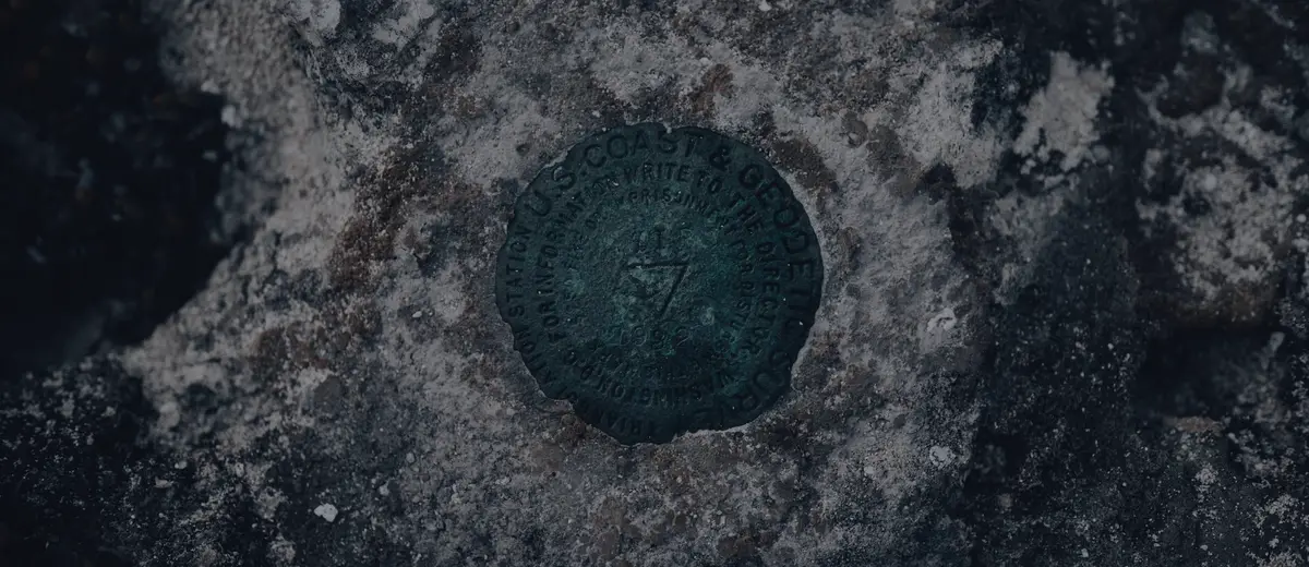 A weathered survey benchmark disk set into rock.
