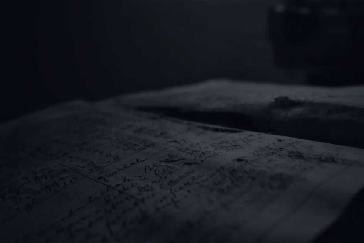 A dark close-up of a printed financial statement, representing reading a credit card statement.