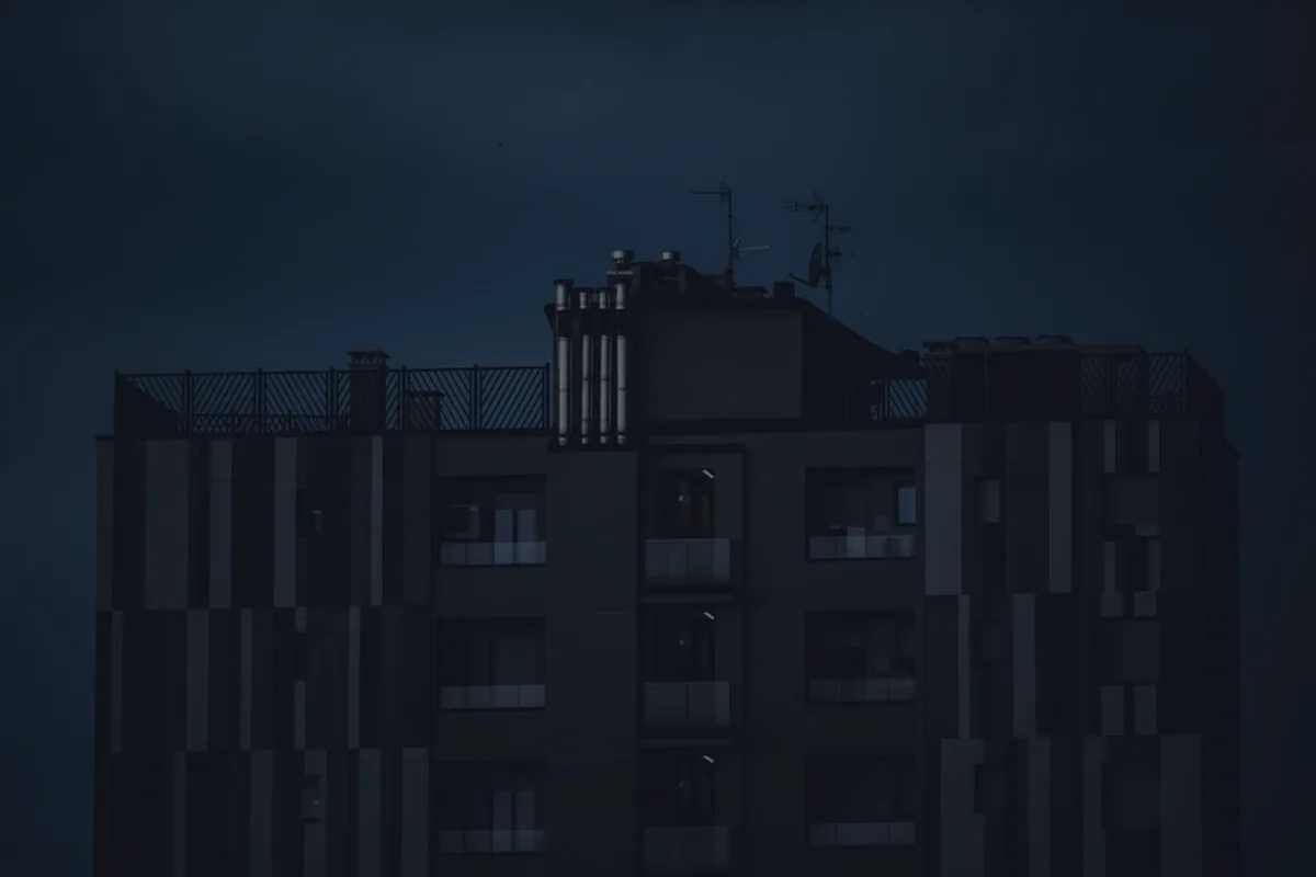 An apartment building at dusk in dark tones, representing rental property basics.