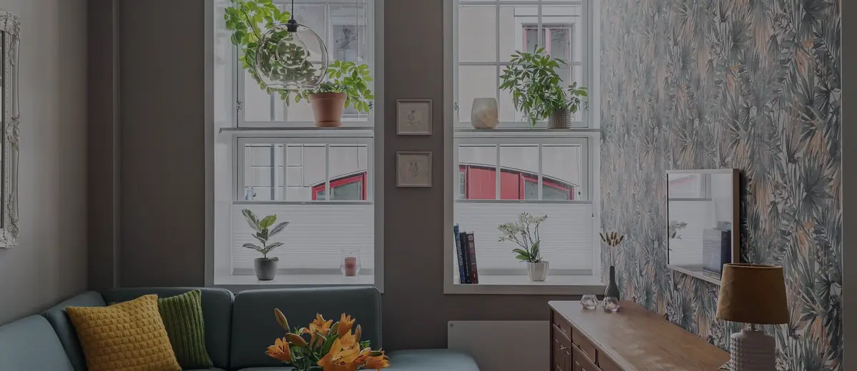 A bright apartment living room with plants by the window.