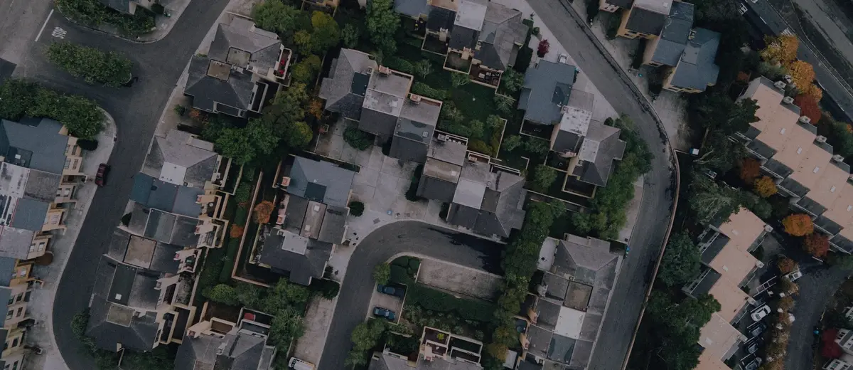 An aerial view of suburban houses along a curving street.