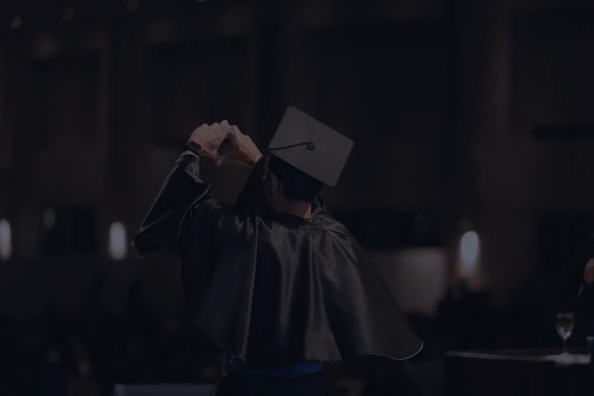 A dark, dramatically lit graduation cap, representing student loan repayment.