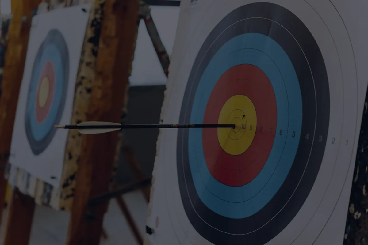 An archery target in dark dramatic light, representing target-date funds.