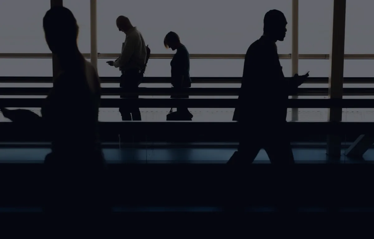 Silhouettes in an office at dusk, representing when to hire a financial advisor.