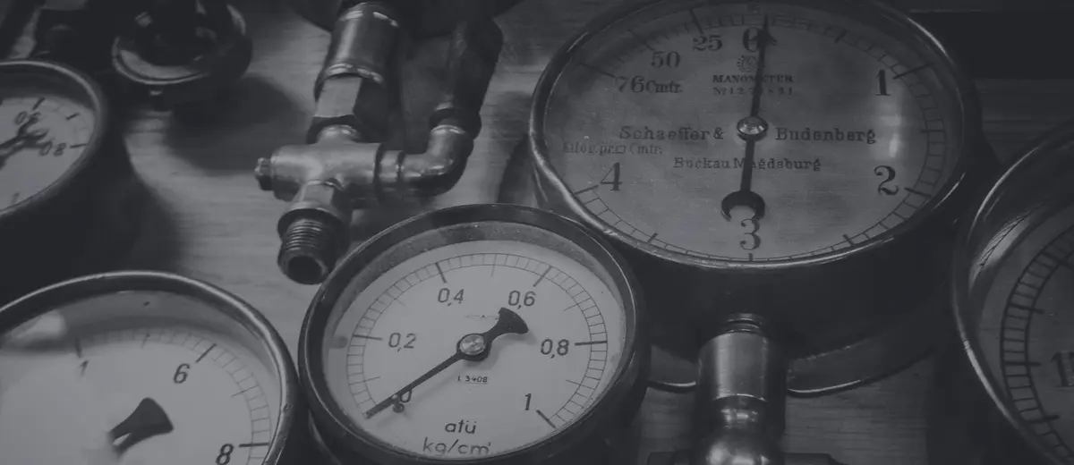 Several vintage pressure gauges, each showing a different reading, in black and white.