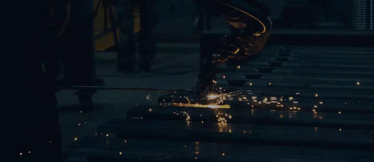 Sparks flying across a dark metal workshop floor.